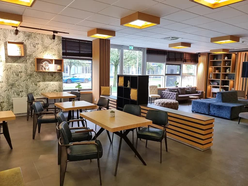 Community-Area des myMINGA Airport mit Lounge und Frühstückstisch